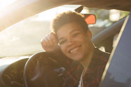 happy and beautiful african american woman with short hair in a car, lifestyle.