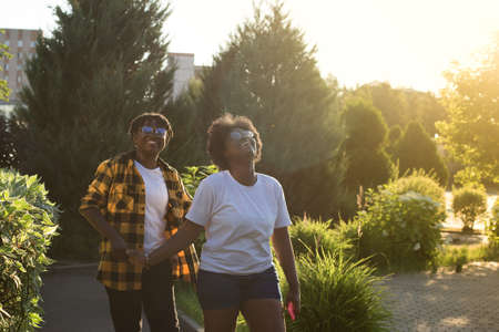 two happy African-American women are walking down the street in the summer.の写真素材