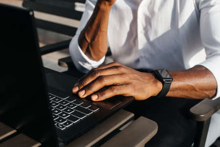 African-American businessman, works at a laptop in a cafe, freelancer.