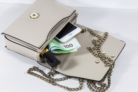 women's handbag with money, lipstick and phoneの写真素材