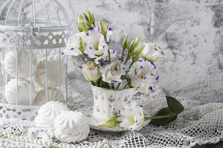 marshmallow, cup and flowers on the tableの写真素材