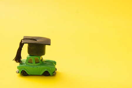 Toy mini car with a graduated cap. Driving leaning concept.の写真素材