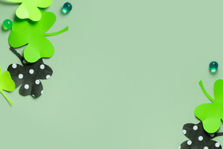 St. Patrick's Day minimalistic background. Paper clover leaves on colored background with copy...