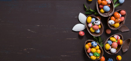 Banner with chocolate eggs and bunny on wooden table copy space. Happy Easter egg hunt concept...