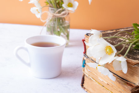 Anemones flower close-up and vinage books with cup of drink. Spring, Mother's Day or March 8 still life composition.の写真素材