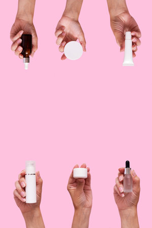 Female hands with cosmetic products in different containers and bottles mock up isolated on pink color background. vertical format.の写真素材