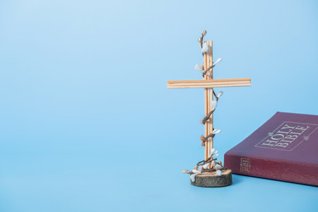 Cross decorated flowers with Holy Bible on blue background. Easter holiday minimalistic concept. copyspace.の写真素材