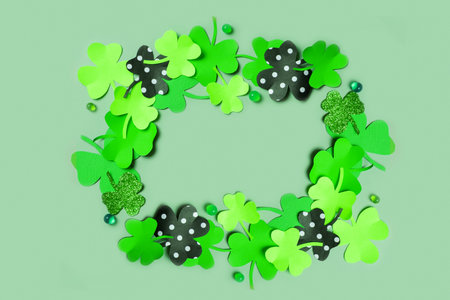 St. Patrick's Day frame background. Paper clover leaves on colored background with copy space.の写真素材