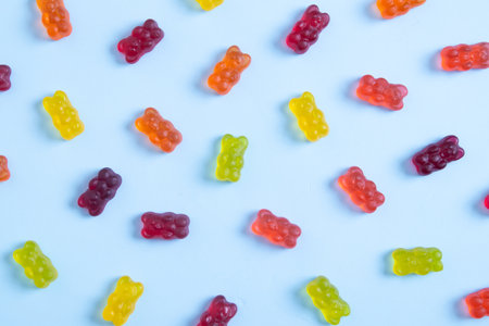 Colored jelly bears on a pastel blue background. top view.の写真素材