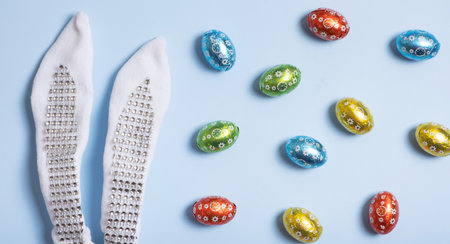 Easter hunt flat lay concept. Creative composition with bunny ears and chocolate eggs.