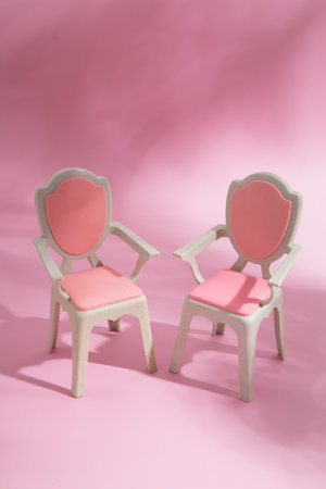 Abstract composition still life two puppet chairs on a pink backgroundの写真素材