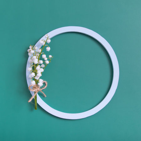 Summer or spring composition. Lily of the valley flowers with round frame copy space top view. Summer, spring floral concept.の写真素材