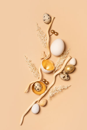 Golden beige colors Easter still life composition. Easter eggs, decoration with twigs and flowers.の写真素材