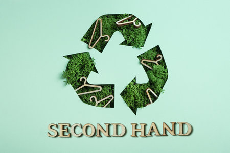 Second hand text and green moss under paper cut recycling symbol. Save planet, eco, recycling cloth concept.の写真素材