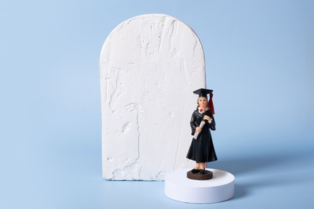 A statuette of a graduate on a podium with a mock-up of a cement board for a text classの写真素材