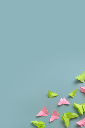 Paper butterfies green and pink colors flat lay on a colored background. copyspace. vertical format.の写真素材
