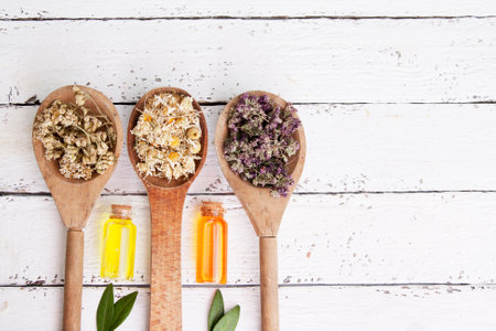 Wooden spoons with dried medicinal herbs and bottles with essence. Medicinal teas and tinctures as an alternative medicineの写真素材