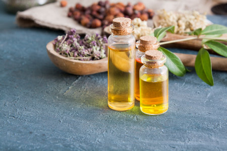Herb tinctures in glass bottles on a dark concrete table. Traditional medicine and herbal treatment concept.の写真素材