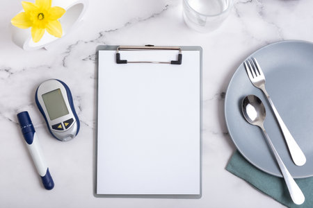 Empty text board and glucometer and cutlery with alarm clock on plate flat lay, top view. Mock up diabetes theme.の写真素材