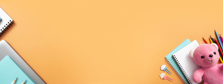 Notebooks, teddy bear and stationary on colored background. copyspace. Kids work space top view, flat lay. online learning concept.の写真素材