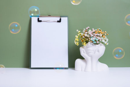 Message board mockup with head vase with flowers and soap bubbles. Mind care, mental health concept.の写真素材