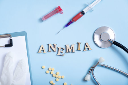 Anemia text with container for blood analysis, stethoscope, pills, syringe flat lay, top view.の写真素材