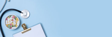 Fragment of stethoscope, tablet, pills with copy space. Health care and medicine banner concept flat lay, top view.の写真素材