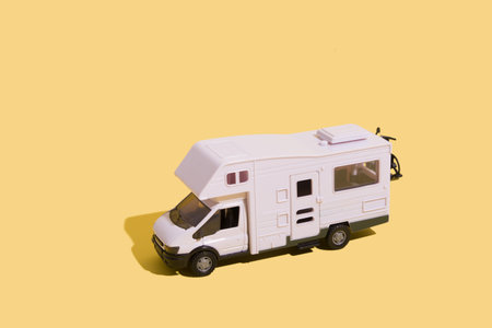 Irpin, Ukraine, June 10, 2021 - toy van on a yellow background. Minimalistic summer family vacation concept.の写真素材