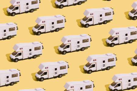 Irpin, Ukraine, June 10, 2021 - Pattern of a toy van on a yellow background. Minimalistic summer family vacation concept.の写真素材