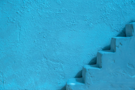 Blue concrete wall and stairs. Abstract interior summer background.の写真素材