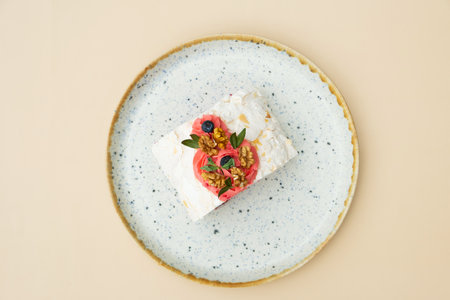 Meringue roll in round plate flat lay composition on beige background.の写真素材