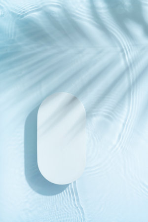 Podium or pedestal with water ripple and palm shadow flat lay, top view. Summer cosmetic template, mock up.の写真素材