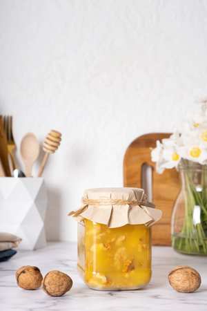Jar with nuts honey on the kitchen interior with flowers.の写真素材