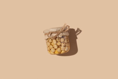 Glass jar with honey and nuts on beige background. Sweet food.の写真素材