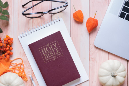 Holy bible and autumn cozy top view on wooden background. Bible study autumn concept.の写真素材