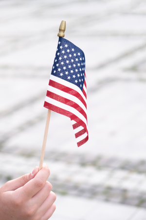 American flag in boy's hand outdoors. 4th july USA independence day concept.