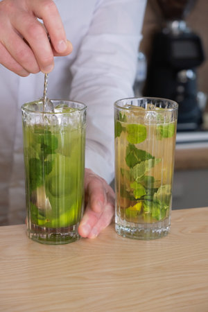 Preparation of a mojito cocktail by a bartender in a cafe. Summer cold drinkの写真素材