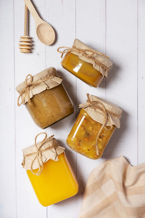 Jars with honey and nuts honey on wooden background top view, flat lay.の写真素材