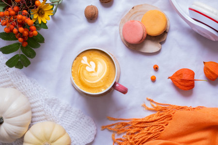 Cup of latte and autumn cozy decor with sweater and pumpkins top view.の写真素材