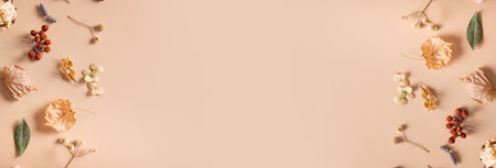 Autumn banner. Pattern made of dried leaves and flowers on pastel beige background. Autumn, fall concept. Flat lay, top view, copy space.の写真素材