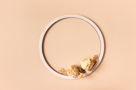 Autumn composition. Wooden ring and dried flowers on pastel beige background. Autumn, fall concept. Flat lay, top view, copy spaceの写真素材