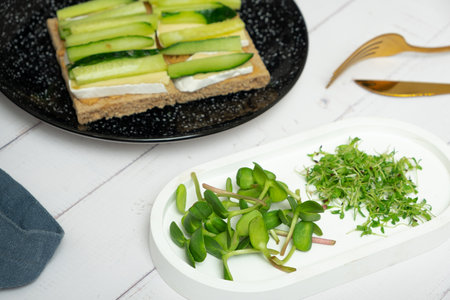 Microgreens sunflower and alfalfa with cutlery on the tableの写真素材