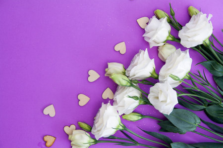 Lilac-white Texas bluebell with a lilac background and hearts. Place for text