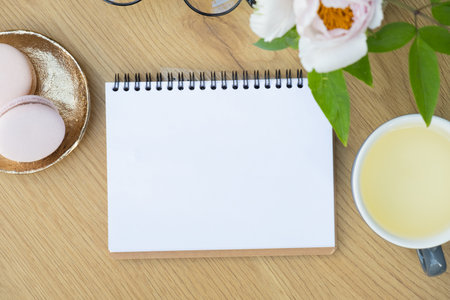 Blank note with cup of tea and macaroons on cafe table background.の写真素材