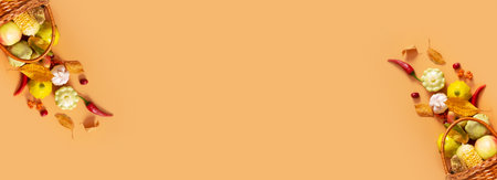 Autumn banner with harvest basket with corn, apples, zucchini and peppers on a orange background with copy space.の写真素材