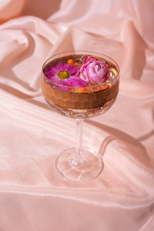 Autumn still life from glass with beverage with mountain ash and dried leaf on folded fabric background. Minimalistic creative autumn concept.の写真素材