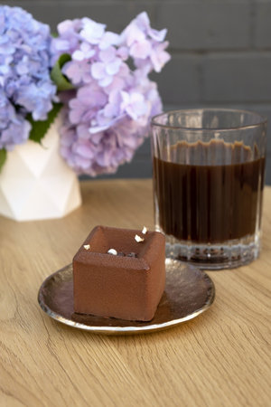 Chocolate mousse cake on a wooden cafe table.