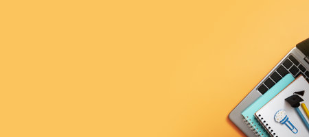 Colorful pencils with graduated cap and note on laptop on colored background. copyspace. Children...