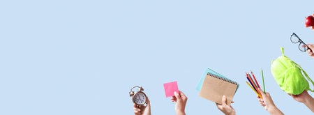 Banner with school stationary in female hands on blue color background with copy space. Back to school concept.の写真素材