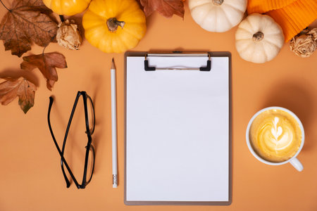 Flat lay blank tablet for text next to pumpkins and autumn leaves with coffee cup. Autumn theme mockup.の写真素材